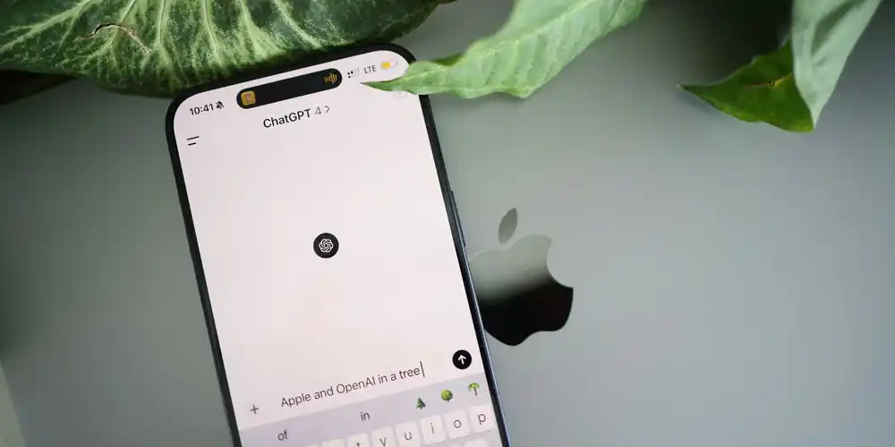 Smartphone showing an AI chat interface resting on a laptop